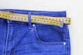 Jeans and measuring subject for weight loss on yellow background