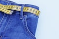 Jeans and measuring tape close-up, concept of healthy lifestyle and losing weight, copy space Royalty Free Stock Photo