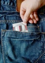 Jeans pocket with condom in hand Royalty Free Stock Photo