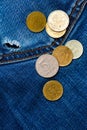 Jeans pocket with hole and coins Royalty Free Stock Photo