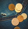 Jeans pocket with hole and coins Royalty Free Stock Photo