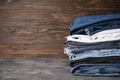 Jeans stacked in a stack, on a wooden background, place for text Royalty Free Stock Photo