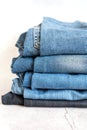 jeans are stacked on a white background. stack of several fashionable women`s or teenage casual all-season denim pants clothing b