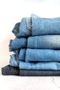 Jeans are stacked on a white background. stack of several fashionable women`s or teenage casual all-season denim pants clothing b