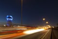 Jeddah water tower at night, with car lights motion on the street.