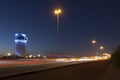 Jeddah water tower at night, with car lights motion on the street.