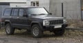 Jeep cherokee in black color standing by the wire mesh fence . Royalty Free Stock Photo