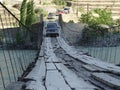 A jeep drives over a rope bridge over a river Royalty Free Stock Photo