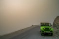 Jeep on a mountain road during storm