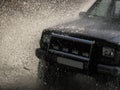 Jeep passes through the water creating large spray of water