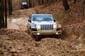 Jeep Rubicon JK climbing a hill on a muddy trail.