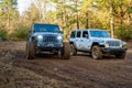 Jeep Rubicons on a muddy trail for race.