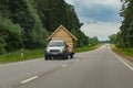 Jeep truck hauling small decorated wooden cabin