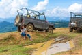 Jeeping car mountain travel. Beautiful girl rest next dirty jeep and big puddle of mudd Royalty Free Stock Photo
