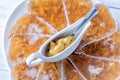 Jellied meat with mustard in a bowl and spoon on white plate close up