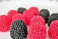 Jelly candies in the form of raspberries, red and black on a white background