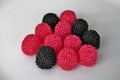 Jelly candies in the form of raspberries, red and black on a white background