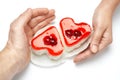 Jelly heart-shaped cakes in hands of lovers