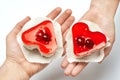 Jelly heart-shaped cakes in hands of lovers