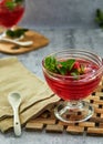 Jelly with strawberries in a glass on a wooden board, against a background of concrete Royalty Free Stock Photo