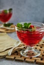 Jelly with strawberries in a glass on a wooden board, against a background of concrete Royalty Free Stock Photo