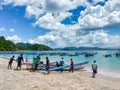 Jember, Indonesia - January 2023 : the fishermen work together to lower the boat to sail on the beach of papuma jember