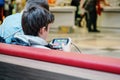 Jena, Germany. March 23 2019. Teenager playing online game on mobile phone or smartphone at shopping center. Gadget addiction