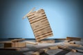 Jenga game, a falling tower of wooden blocks on a blue background and randomly lying wooden blocks