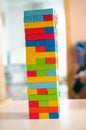Jenga game, a tall tower built from colored blocks