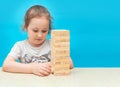 Little girl playing with wooden jenga game