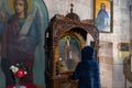Believing woman stands and prays in front of the altar of the Monastery Deir Hijleh - Monastery of Gerasim of Jordan, in the