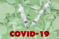 jeringas blancas con pastillas blancas sobre fondo verde texto rojo covid-19white syringes with white tablets on green background Royalty Free Stock Photo