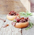 Jerked meat, cow, deer, wild beast or biltong in wooden bowls on a rustic table, selective focus