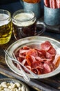 Jerky pork chips on vintage plate with beer on table