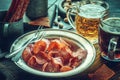 Jerky pork chips on vintage plate with beer on table Royalty Free Stock Photo