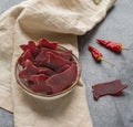 Jerky slices on a background with vegetables