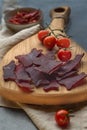 Jerky slices on a background with vegetables