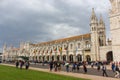 Jeronimos monastery with crowd of visitors. Tourists near ancient abbey in Lisbon. Facade of monastery of St Jerome.