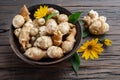Jerusalem artichoke roots with leaves and flower of Jerusalem artichoke on a old wooden table Royalty Free Stock Photo