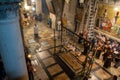 Jerusalem, Israel - 10 April, 2023. Priests, Tourists and pilgrims prayng at the Stone of Anointing in the church of holy