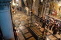 Jerusalem, Israel - 10 April, 2023. Priests, Tourists and pilgrims prayng at the Stone of Anointing in the church of holy