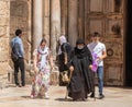 An elderly nun leaves with a small group of young believers after prayer in the Church of the Holy Sepulchre wall in the old city