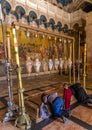 JERUSALEM, ISRAEL - June 25, 2017: People praying at the Stone of Anointing in the Holy Sepulcher Church in Jerusalem.