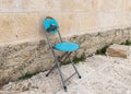 A folding chair with a Dome of the Rock painted on the back stands near the wall on the Temple Mount in the Old Town of Jerusalem