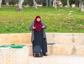 Muslim woman stands and prays on the Temple Mount near to the Golden Gate - Gate of Mercy in the Old Town of Jerusalem in Israel