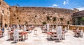 Panoramic view of the Western Wall with rows of tables and chairs for visitors and pilgrims from all over the world. The last