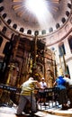 Penetrating sun rays through the rotunda of the dome on aedicula in the Church of the Holy Sepulcher in Jerusalem with visitors Royalty Free Stock Photo