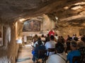 A preacher gives a sermon to visitors in the hall of the Grotto of Gethsemane on foot of the mountain Mount Eleon - Mount of