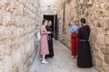Two young monks stand and talk with two young girls near the entrance to Grotto of Gethsemane on foot of the mountain Mount Eleon