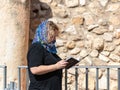 A believing woman reads a prayer in the holy for Jews book Tehelim near the Western Wall in the Old City of Jerusalem, Israel